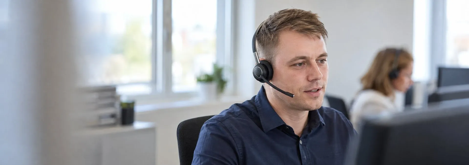 Telefonservice-Mitarbeiter mit Headset im Kundengespräch