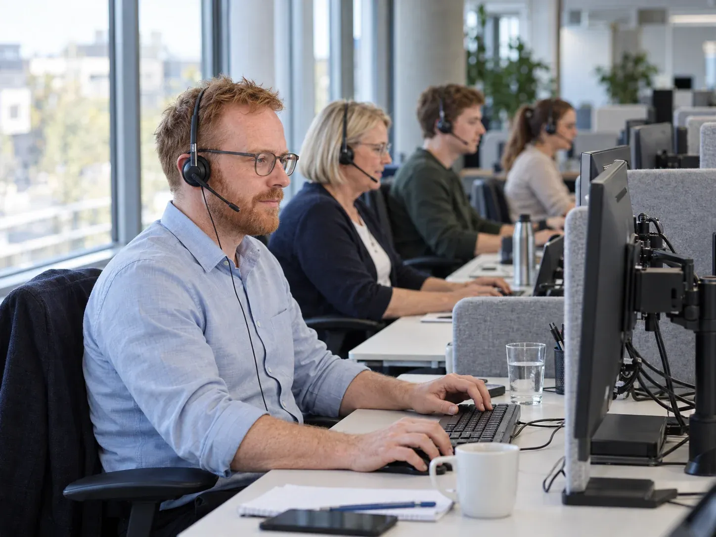 Team im Callcenter mit Agenten an mehreren Serviceplätzen.