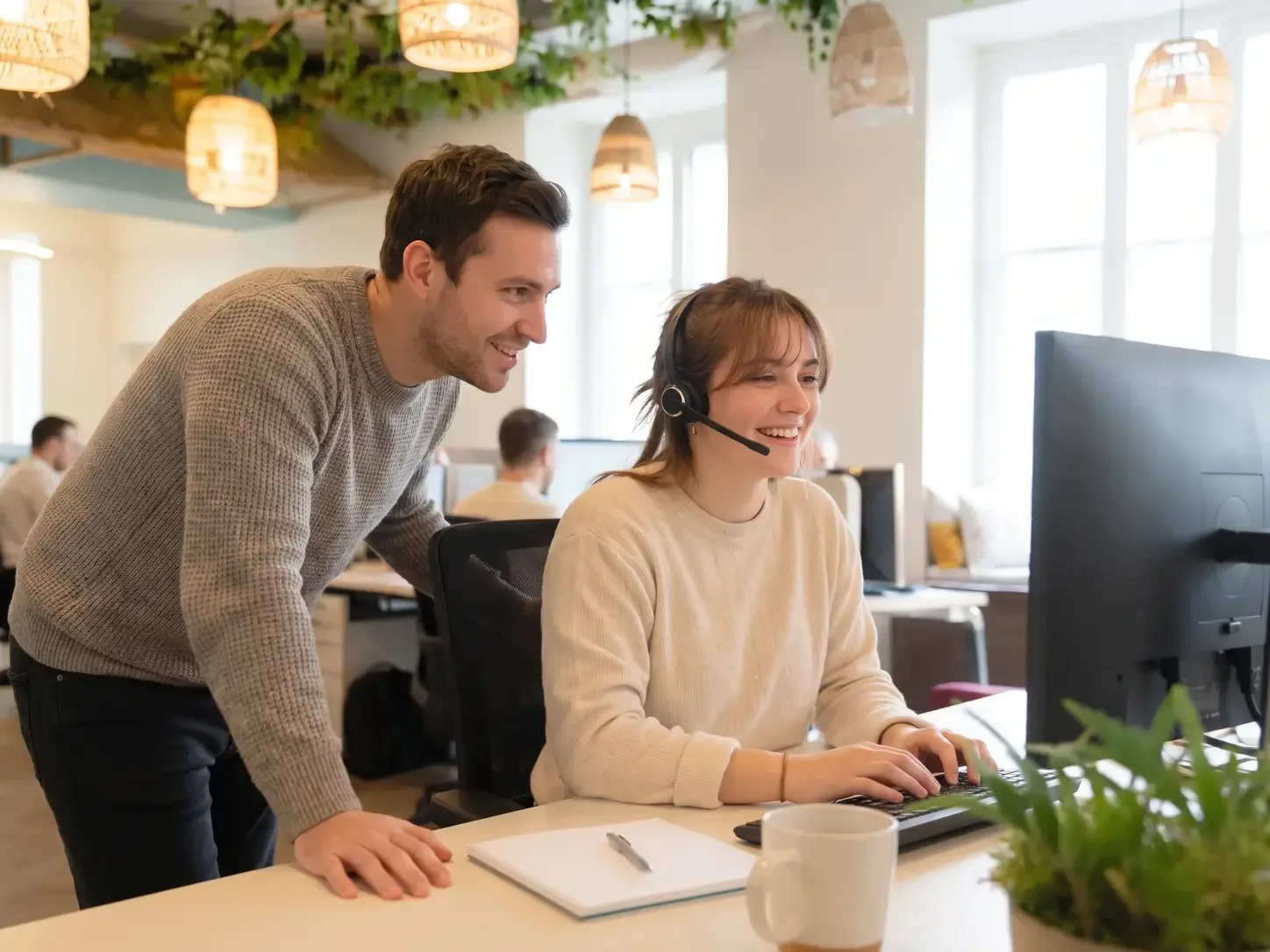 Zwei Kolleginnen und Kollegen von starbuero.de am Arbeitsplatz, eine davon mit Headset am Telefon