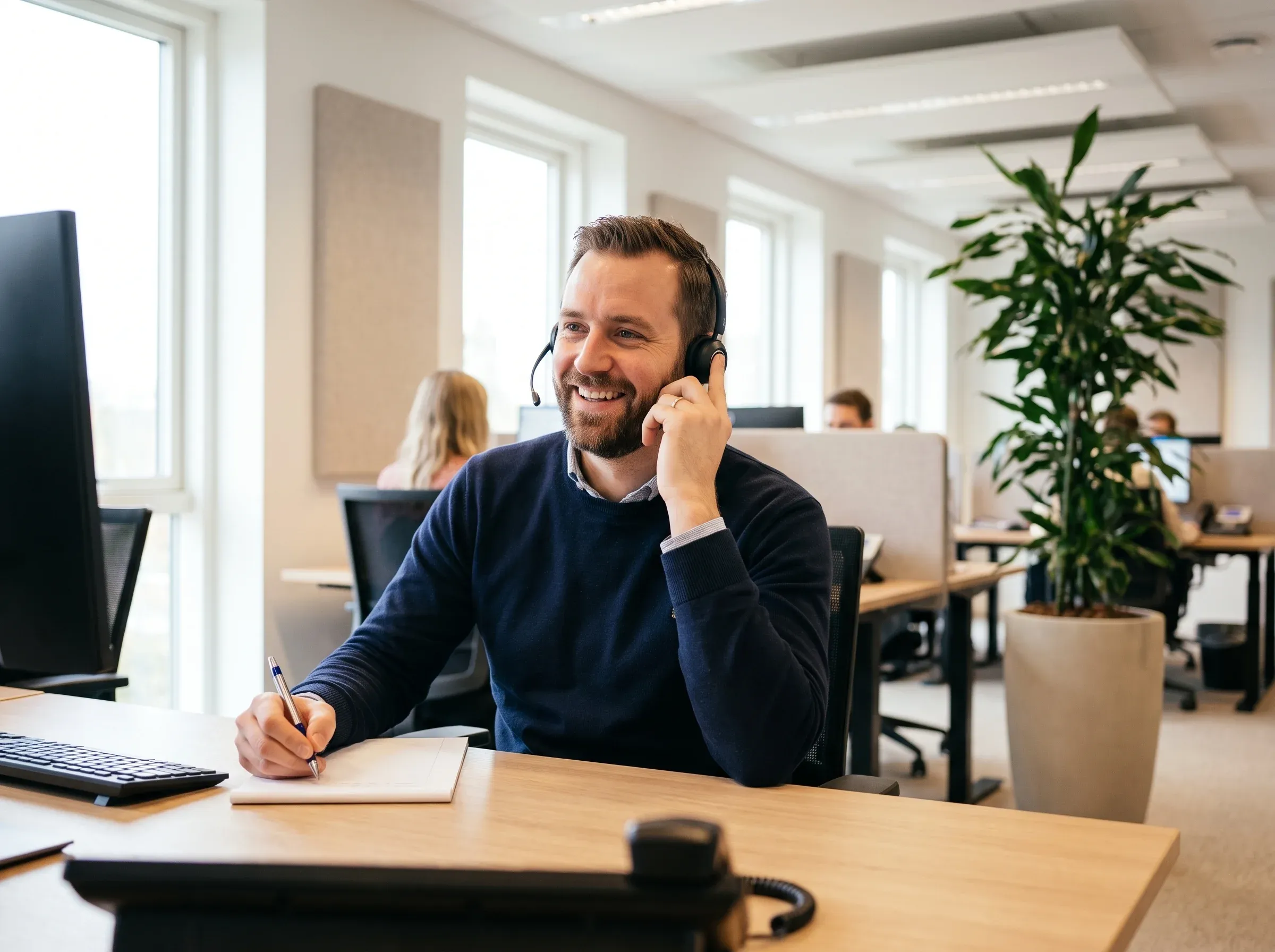 Servicemitarbeiter im Telefondienst nimmt einen Anruf entgegen.